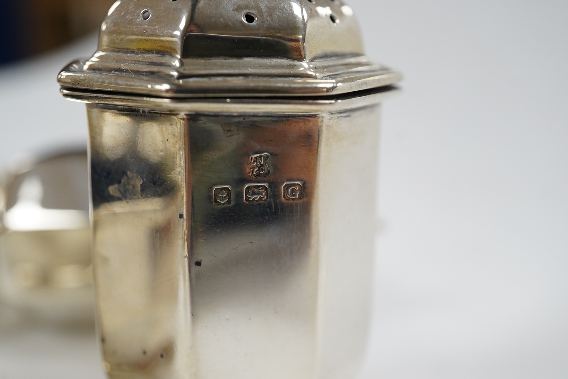 A George V five piece silver condiment set, Birmingham, 1931, two miniature 925 pepperettes and a silver shell salt. Condition - fair